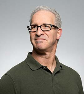 Person in glasses and polo shirt, smiling slightly.